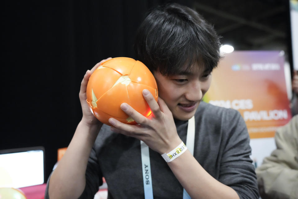 Juho Seo, of Solive Ventures, demonstrates using the Peel & Play educational sensory toy during CES Unveiled before the start of the CES tech show Sunday, Jan. 7, 2024, in Las Vegas. The toy is designed to help children with self-stimulatory behavior. (AP Photo/Ryan Sun)