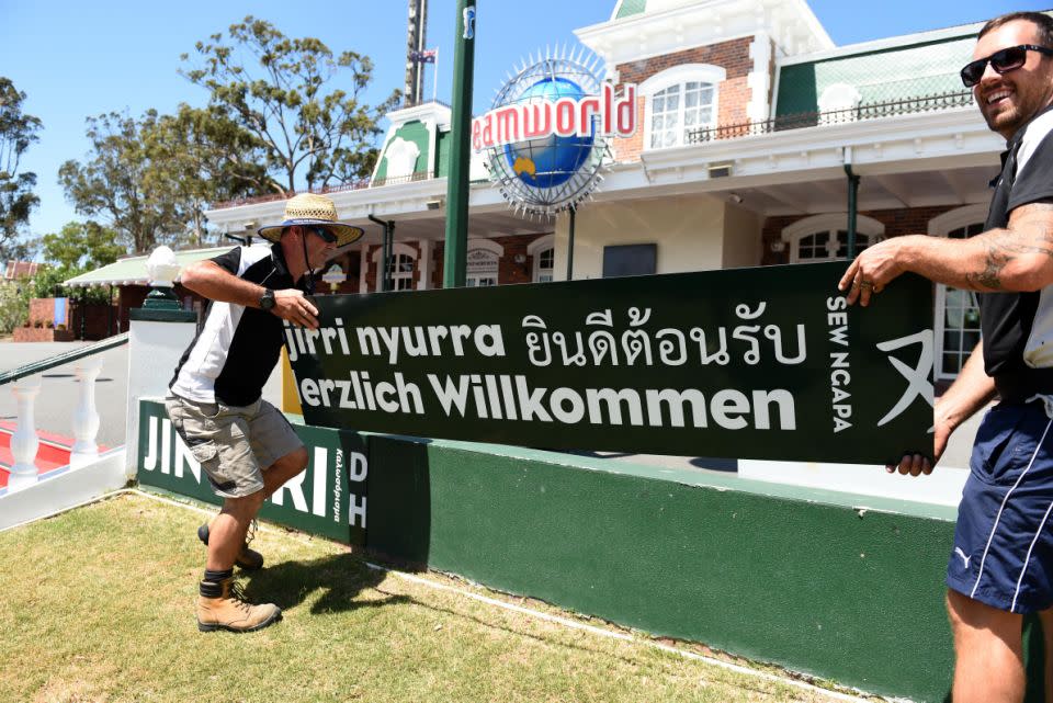 Workers put up a sign welcoming guests to the park. Photo: AAP