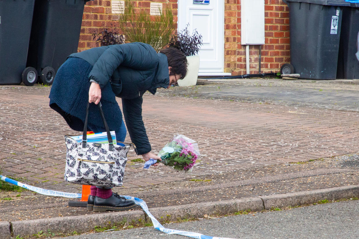 A neighbour leaves flowers near the family's home. (SWNS)