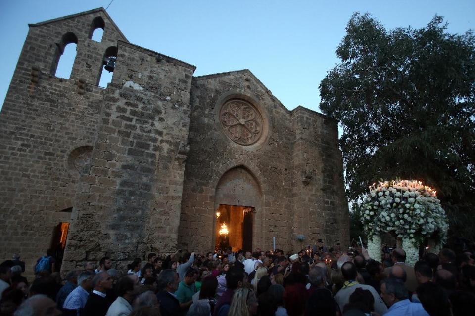 Greek Orthodox Christian worshipers hold aloft the bier depicting Christ’s preparation for burial during a Good Friday service at the church of Ayios Georgios Exorinos in Famagusta, Cyprus’ breakaway Turkish Cypriot north on Friday, April 18, 2014. It’s the first time in nearly 60 years that such a service during Christianity’s holiest week is being held at this 14th century church. Although the island’s conflict has never been about religion, the service is seen as an example of how faith can help mend the island’s ethnic division. (AP Photo/Philippos Christou)