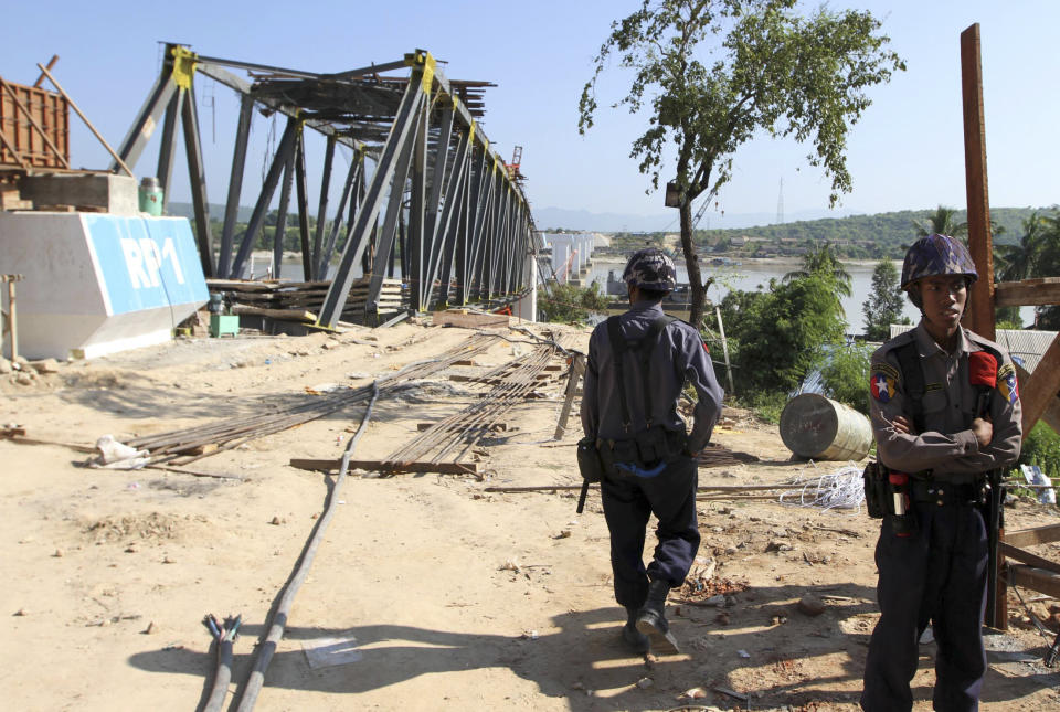 Policemen stand near the Yadanatheinga bridge that has collapsed into water in Irrawaddy River after it was damaged by a strong earthquake, Monday, Nov. 12, 2012, in Kyaukmyaung township in Shwebo, Sagaing Division, northwest of Mandalay, Myanmar. A strong earthquake collapsed the bridge and damaged ancient Buddhist pagodas Sunday in northern Myanmar, and piecemeal reports from the underdeveloped mining region said mines collapsed and as many as 12 people were feared dead. (AP Photo/Khin Maung Win)