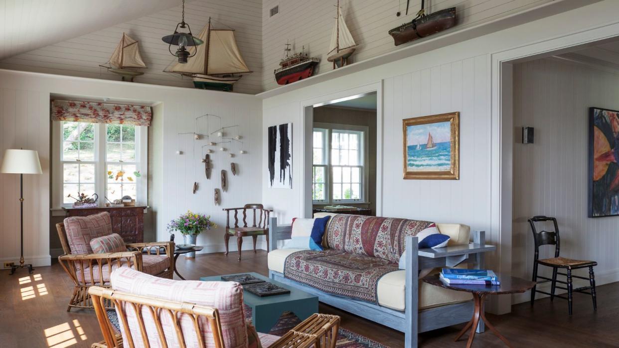  Living room with blue wooden couch and with model boats on high shelf. 