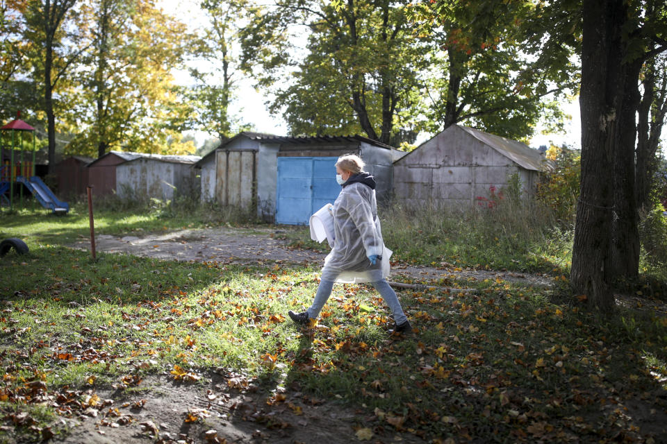 A member of an election commission carry election ballots to a mobile polling station during the Parliamentary elections in Sharapovo village, Moscow region, Russia, Saturday, Sept. 18, 2021. The Communist Party and independent observers have reported an array of alleged violations in the voting that is widely expected to keep the dominant United Russia party's majority in parliament. (Evgeny Feldman/Meduza via AP)