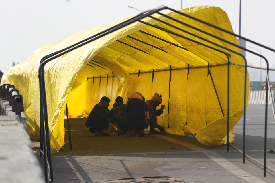 Farmers put up makeshift tents as more of them return to protest against against new farm laws, at the Delhi-Uttar Pradesh border, on the outskirts of New Delhi, India, Saturday, Jan. 30, 2021. Indian farmers and their leaders spearheading more than two months of protests against new agriculture laws began a daylong hunger strike Saturday, directing their fury toward Prime Minister Narendra Modi and his government. Farmer leaders said the hunger strike, which coincides with the death anniversary of Indian independence leader Mahatma Gandhi, would reaffirm the peaceful nature of the protests. (AP Photo/Manish Swarup)