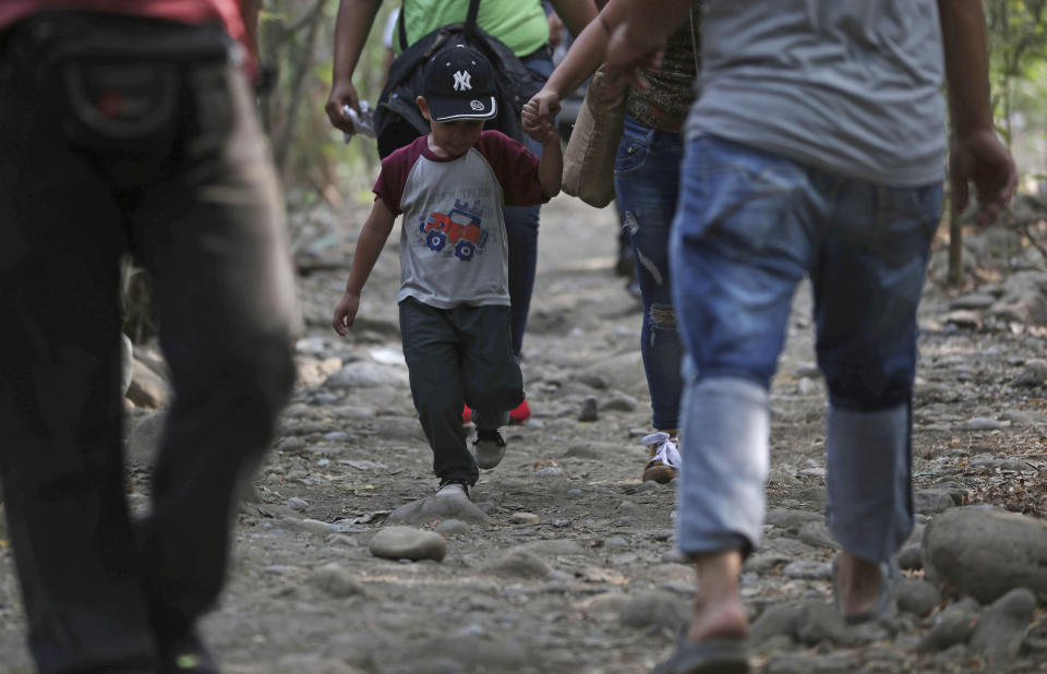 A boy holds an adult's hand as he crosses illegally into Colombia with them near the Simon Bolivar International Bridge, which remains closed by Venezuelan authorities, in La Parada, near Cucuta, Colombia, Sunday, March 3, 2019. Last weekend, Venezuelan opposition leader Juan Guaido coordinated a failed effort to bring aid from Colombia and Brazil into Venezuela, where security forces loyal to Venezuelan President Nicolas Maduro blocked the supplies at its border bridges, which remain closed, with Maduro describing Guaido’s gambit as part of a U.S.-backed plot to overthrow him. (AP Photo/Martin Mejia)