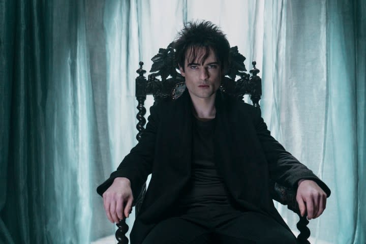 A man sits on a throne and stares.