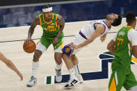 Denver Nuggets guard Facundo Campazzo, right, falls as Utah Jazz guard Jordan Clarkson (00) drives during the first half of an NBA basketball game Friday, May 7, 2021, in Salt Lake City. (AP Photo/Rick Bowmer)