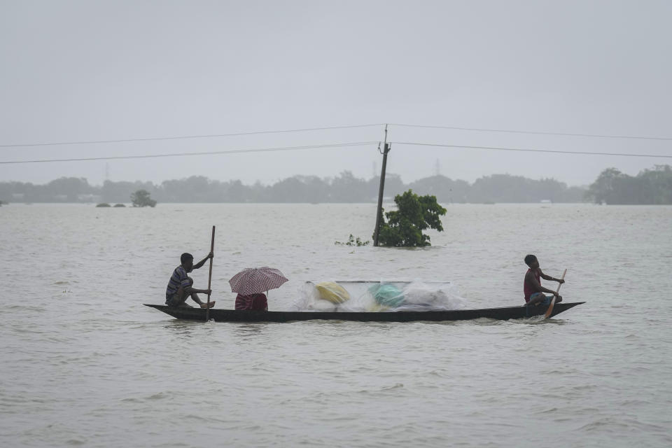 Flood affected people travel with their belongings through flood waters in Sildubi village in Morigaon district in the northeastern state of Assam, India, Tuesday, July 2, 2024. Floods and landslides triggered by heavy rains have killed more than a dozen people over the last two weeks in India's northeast. (AP photo/Anupam Nath)