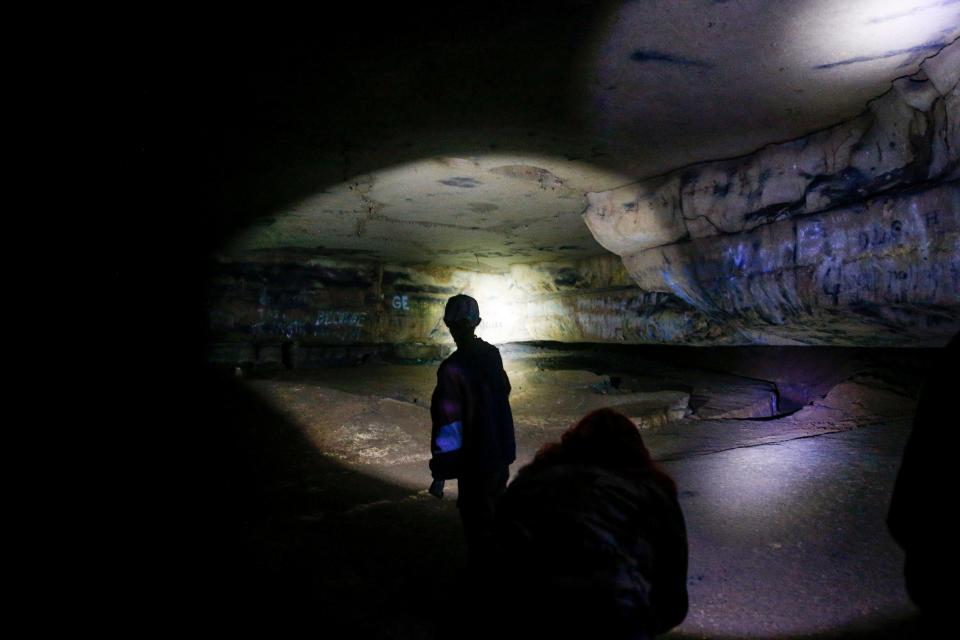 A tour group makes their way through the interior caves, with the guide silhouetted by their flashlight at Dunbar Cave State Park in Clarksville, Tenn., on Thursday, May 20, 2021. 