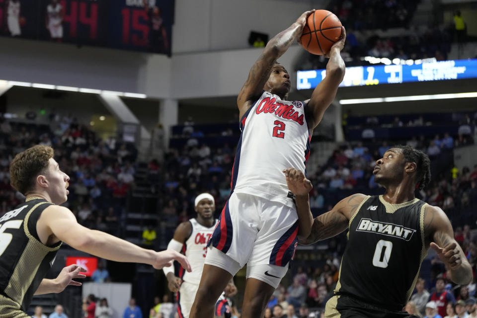 Mississippi guard TJ Caldwell (2) leans into his 3-point basket-attempt over Bryant guard Earl Timberlake (0) during the first half of an NCAA college basketball game, Sunday, Dec. 31, 2023, in Oxford, Miss. (AP Photo/Rogelio V. Solis)