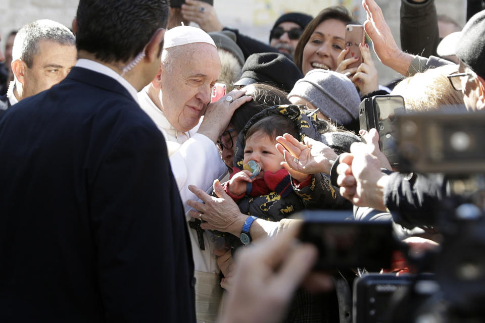 Pope Francis caresses a woman as he greets faithful at the St. Nicholas Basilica, in Bari, Italy, Sunday, Feb. 23, 2020. The Pope is in Bari to preside the closing of the “Mediterranean sea a border of peace” conference. Twenty bishops from the countries overlooking the Mediterranean are attend to talk about peace and dialogue. (AP Photo/Gregorio Borgia)