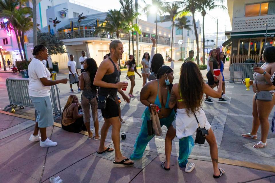 A group of tourists dance on Ocean Drive during spring break in Miami Beach on March 22, 2021.