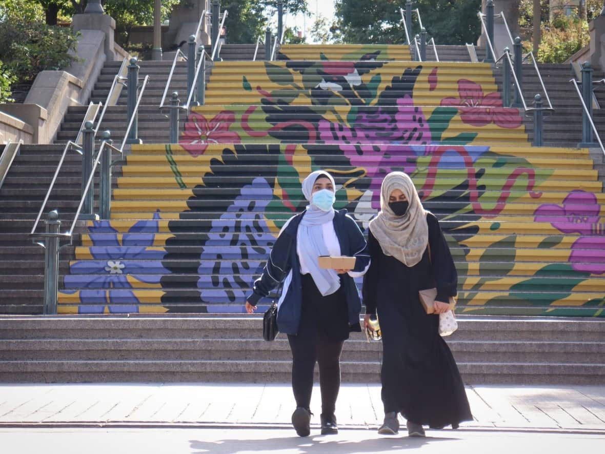 Two people wearing masks cross Sussex Drive in Ottawa in September 2021. (Trevor Pritchard/CBC - image credit)