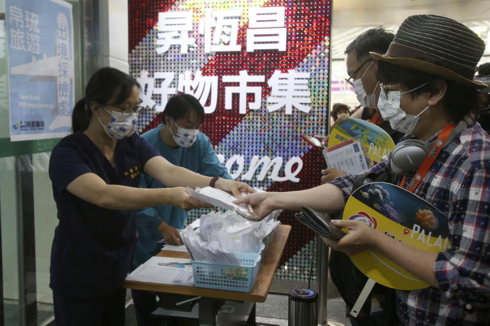 Taiwanese travelers, right, of the first group of Palau-Taiwan Travel Corridor prepare to take COVID-19 virus antigen test before leaving Taiwan, at Taoyuan International Airport in Taoyuan, northern Taiwan, Thursday, April 1, 2021. The Palau-Taiwan Travel Corridor, allowing people to travel between the islands without a COVID-19 quarantine, has started Thursday. (AP Photo/Chiang Ying-ying)