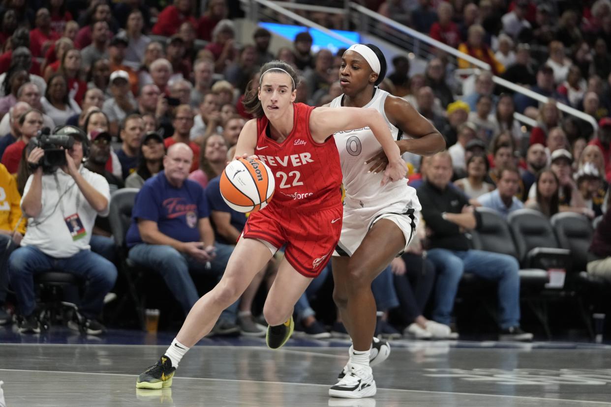 Indiana Fever's Caitlin Clark (22) goes to the basket against Las Vegas Aces' Jackie Young (0) during the first half of a WNBA basketball game, Wednesday, Sept. 11, 2024, in Indianapolis. (AP Photo/Darron Cummings)