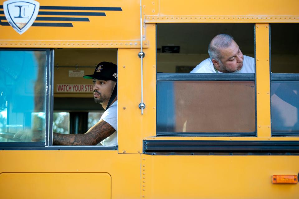 Coachella Valley Unified School District bus driver instructor Frank Espinoza, right, checks the position of the bus as trainee Anthony Thomas looks on in Thermal, Calif., on August 31, 2022. 