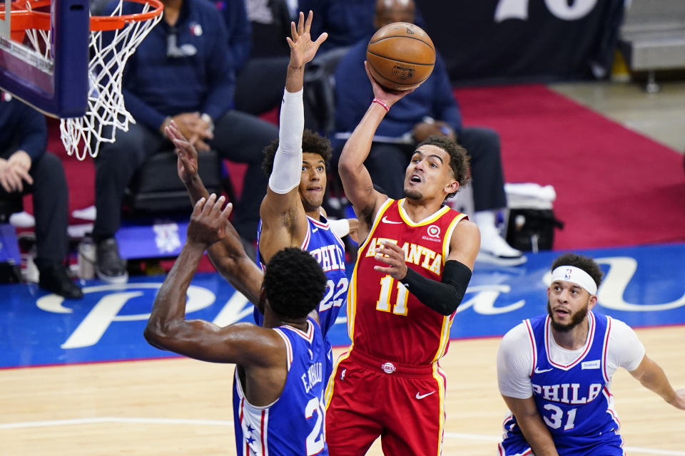 Atlanta Hawks' Trae Young (11) goes up for a shot against Philadelphia 76ers' Joel Embiid (21), Matisse Thybulle (22) and Seth Curry (31) during the second half of Game 5 in a second-round NBA basketball playoff series, Wednesday, June 16, 2021, in Philadelphia. (AP Photo/Matt Slocum)