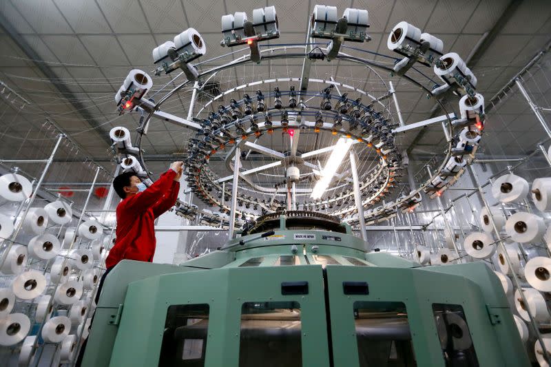 Textile worker is seen on a fabric production line at a factory in Qingdao