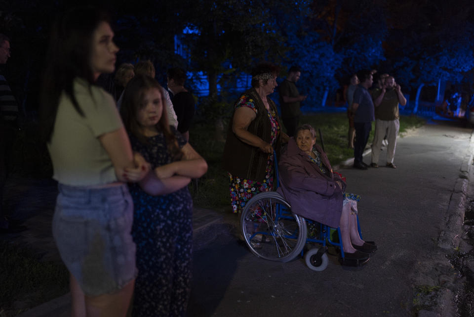 Residents stand outside an apartment building damaged in Russia's air attacks in Kyiv, Ukraine, Thursday, July 13, 2023. (AP Photo/Jae C. Hong)