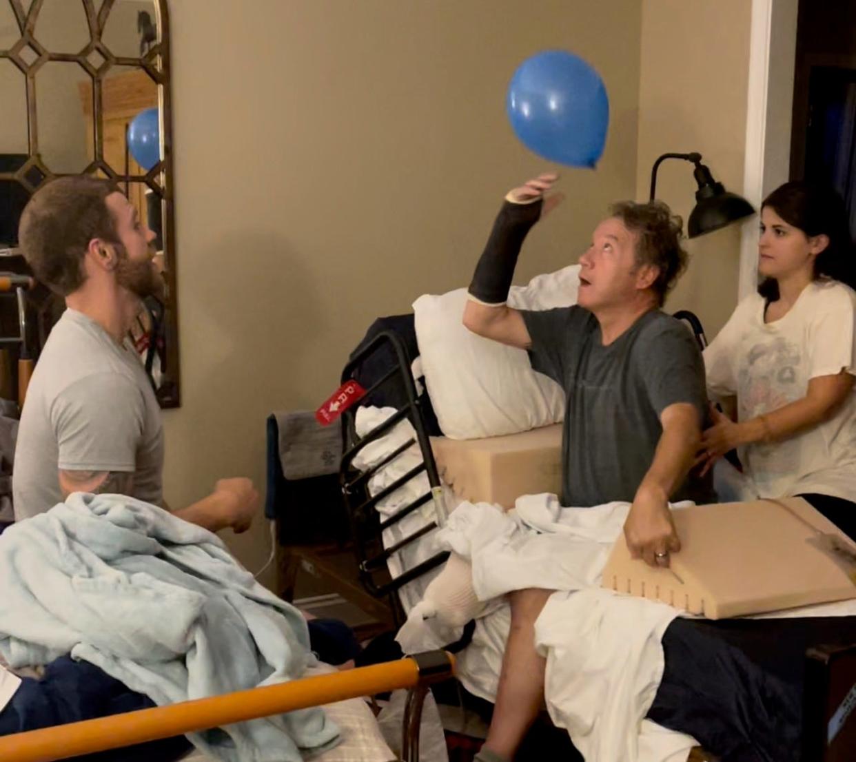 Grant Taylor, left, and Brenna Mauro, help Scott Spitnale with a balance exercise.