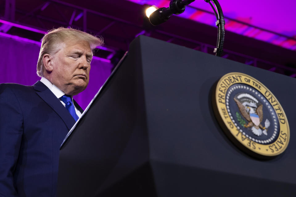 FILE - In this Saturday, Oct. 12, 2019, file photo, President Donald Trump bows his head down as they say their prayer at the Values Voter Summit in Washington. Trump’s appeal to religious conservatives is a cornerstone of his political identity. But Joe Biden is a different kind of foe than Trump has faced before: one who makes faith a central part of his persona – often literally wearing it on his sleeve. (AP Photo/Manuel Balce Ceneta, File)