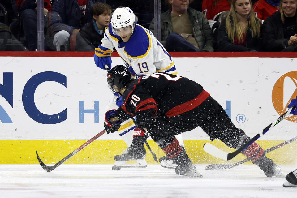 Buffalo Sabres' Peyton Krebs (19) protects the puck from Carolina Hurricanes' Sebastian Aho (20) during the first period of an NHL hockey game in Raleigh, N.C., Saturday, Dec. 2, 2023. (AP Photo/Karl B DeBlaker)