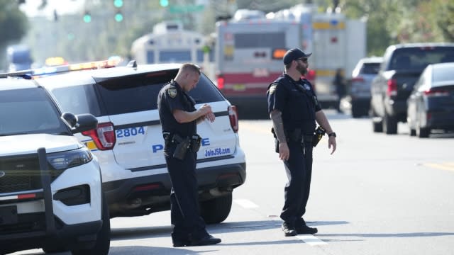 Jacksonville police officers block the perimeter of the scene of a mass shooting.