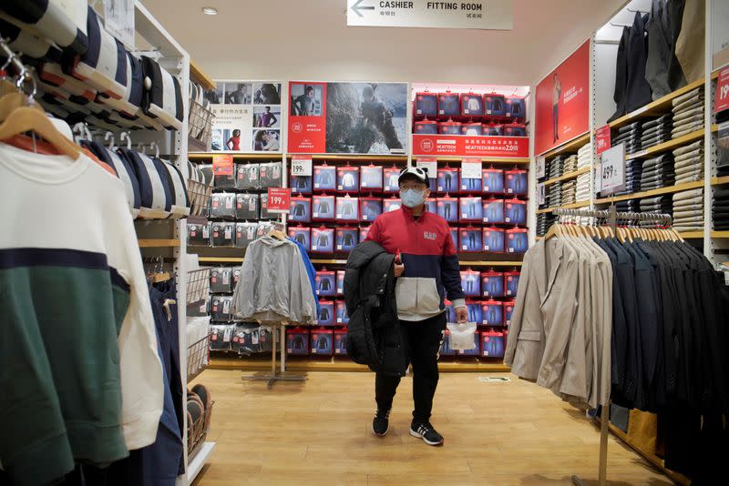 Customer wearing a face mask shops at a Uniqlo store inside a shopping mall in Beijing