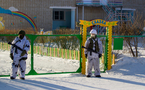 Police officers guard the area around the school in Ulan-Ude after the attack - Credit: Anna Ogorodnik/AP Photo