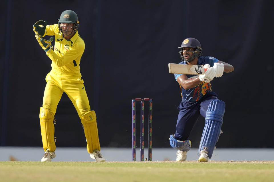 Sri Lanka's Chamika Karunaratne plays a shot as Australia's wicketkeeper Alex Carey watches during the fifth one-day international cricket match between Australia and Sri Lanka in Colombo, Sri Lanka, Friday, June 24, 2022. (AP Photo/Eranga Jayawardena)