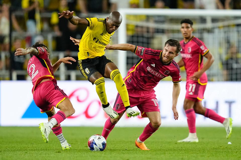 Jul 23, 2023; Columbus, Ohio, USA;  Columbus Crew midfielder Darlington Nagbe (6) gets fouled as he jumps between St. Louis City midfielder Célio Pompeu (12) and St. Louis City midfielder Indiana Vassilev (19) during the second half of the Leagues Cup match at Lower.com Field. The Crew won 2-1.