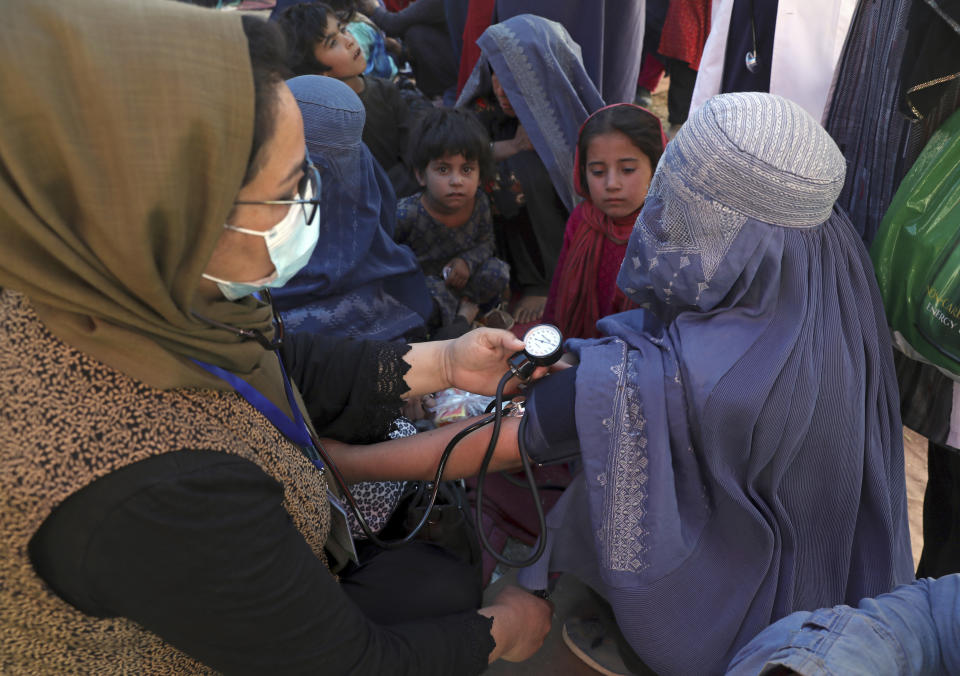 An internally displaced woman from northern provinces, who fled her home due to fighting between the Taliban and Afghan security personnel, has her blood pressure taken after taking refuge in a public park in Kabul, Afghanistan, Tuesday, Aug. 10, 2021. (AP Photo/Rahmat Gul)