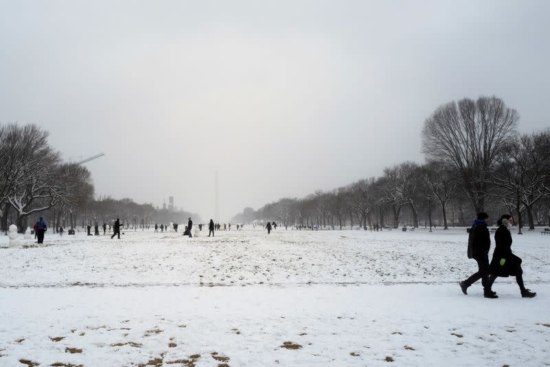 People play in the snow at the National Mall in Washington