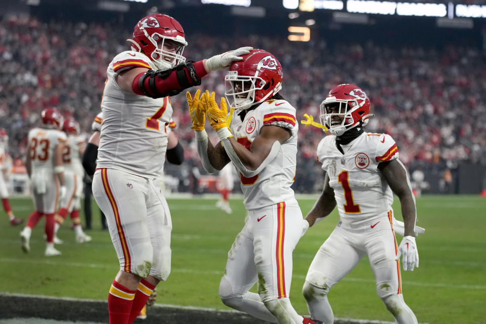 Kansas City Chiefs running back Isiah Pacheco, center, is congratulated by teammates Andrew Wylie, left, and Jerick McKinnon (1) after scoring during the second half of an NFL football game against the Las Vegas Raiders Saturday, Jan. 7, 2023, in Las Vegas. (AP Photo/John Locher)