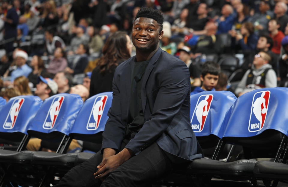 Injured New Orleans Pelicans forward Zion Williamson smiles as he jokes with fans while waiting on the team bench for the second half of the team's NBA basketball game against the Denver Nuggets on Wednesday, Dec. 25, 2019, in Denver. The Pelicans won 112-100. (AP Photo/David Zalubowski)