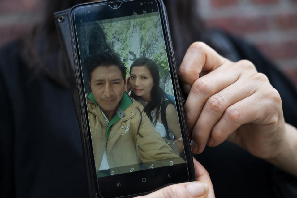 Monica Muquinche holds a picture of herself with her husband Carlos Lopez in her neighborhood in the Brooklyn borough of New York, Thursday, Aug. 26, 2021. Muquinche, whose husband disappeared in 2020 while trying to reach the U.S., is part of an extraordinary wave of Ecuadorians coming in the United States. (AP Photo/John Minchillo)