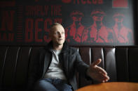 Loyalist activist Jamie Bryson speaks to the Associated Press in the Con Club in East Belfast, Northern Ireland, Tuesday, Oct. 15, 2019. People here are worried that UK Prime Minister Boris Johnson will sacrifice their interests in hopes of securing a deal. Anything that treats Northern Ireland differently than the rest of the U.K. would be unacceptable. "There would be an organic explosion of anger and people would take to the streets and obviously any sensible person would be urging people ... to do so peacefully,'' said Bryson, editor of the Unionist Voice newsletter, as he offered an analysis of where the community stands. (AP Photo/Peter Morrison)