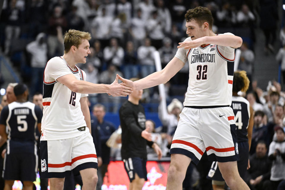 UConn guard Cam Spencer (12) and UConn center Donovan Clingan (32) celebrate in the second half of an NCAA college basketball game against Butler, Tuesday, Feb. 6, 2024, in Hartford, Conn. (AP Photo/Jessica Hill)