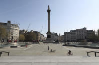 Only a few people in Trafalgar Square, with Nelson's Column at centre, in central London, on a normally busy long holiday weekend, Friday April 10, 2020. Britain's Prime Minister Boris Johnson was moved out of the intensive care unit where he has been undergoing treatment for coronavirus. The highly contagious COVID-19 coronavirus has impacted on nations around the globe, many imposing self isolation and exercising social distancing when people move from their homes. (Jonathan Brady / PA via AP)
