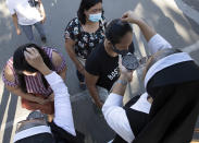 Catholic nuns sprinkle ash on the head of devotees during Ash Wednesday rites Feb. 26, 2020 in Paranaque, metropolitan Manila, Philippines. The Catholic Bishops' Conference of the Philippines has recommended sprinkling ash on the head of devotees instead of using it to mark foreheads with a cross to avoid physical contact and fight the spread of the new coronavirus in the Lenten period in places of worship. (AP Photo/Aaron Favila)