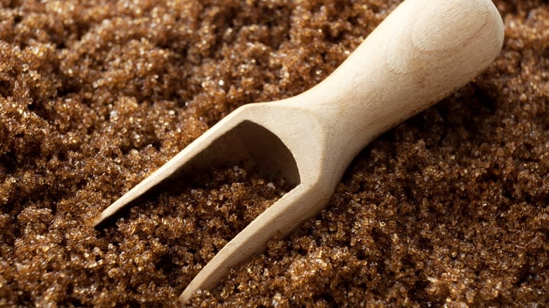 Close-up of a wooden scoop in brown sugar