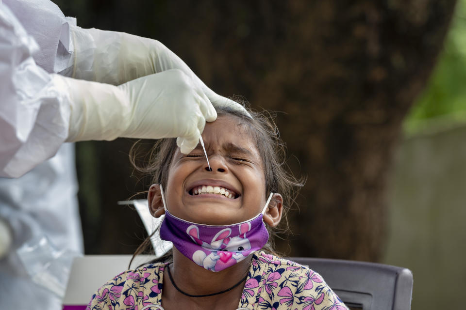 An Indian girl cries as a medical worker collect her swab sample for COVID-19 test at a rural health center in Bagli, outskirts of Dharmsala, India, Monday, Sept. 7, 2020. India's coronavirus cases are now the second-highest in the world and only behind the United States. (AP Photo/Ashwini Bhatia)