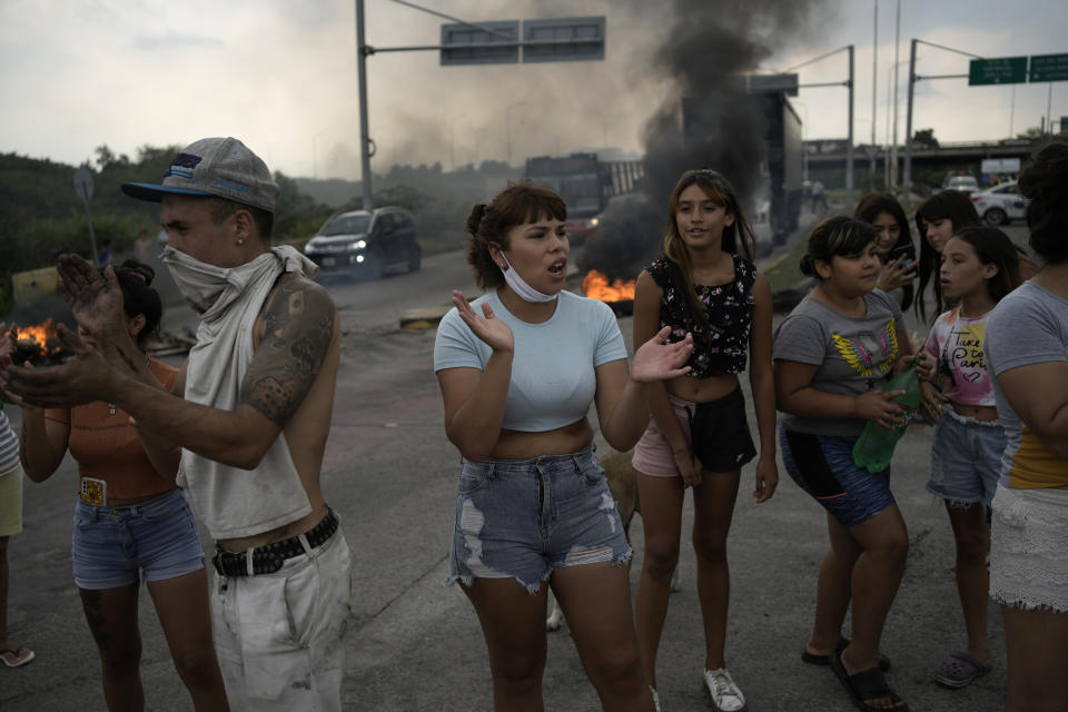 Residents protesting the arrest of fellow neighbors block a street in the "Puerta 8" neighborhood, a suburb north of Buenos Aires, Argentina, Thursday, Feb. 3, 2022, where police say contaminated cocaine may have been sold. A batch of cocaine that has killed at least 20 people and seriously sickened dozens in Argentina appears to have been laced with a synthetic opioid, and police are scrambling to get as much of it off the streets as they can. (AP Photo/Rodrigo Abd)