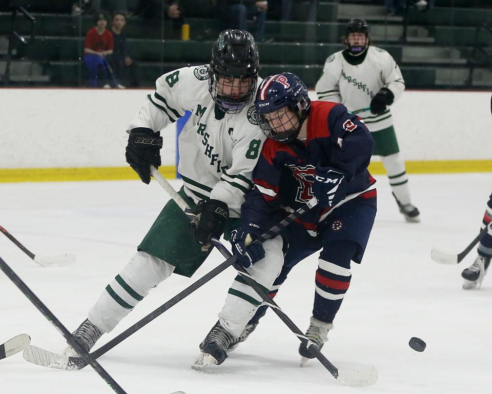 Pembroke's Michael Shaughnessy battles Marshfield’s Jake Hemingway while going after the puck during first period action of their game against Pembroke at the Bog Ice Arena in Kingston on Wednesday, Feb. 15, 2023. 