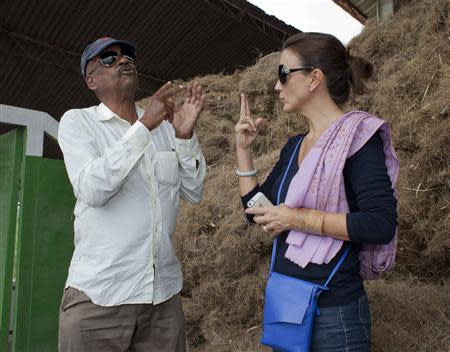 Pierre Leger (L), whose family owns the Agri-supply distillery, the largest Vetiver distillery in the world, talks with Trudi Loren, head of fragrance development at Estee Lauder, while standing next to bales of Vetiver roots at the distillery in Les Cayes, on Haiti's southwest coast, March 27, 2014. REUTERS/stringer