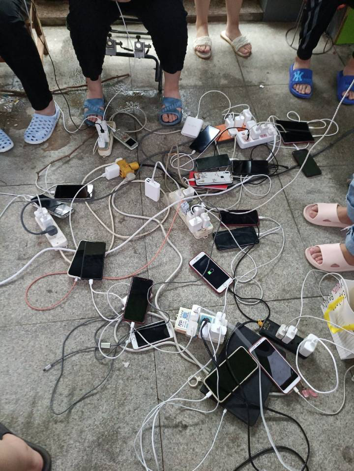 鄭州淹大水，好心的電器行老闆免費為民眾手機充電，方便對外聯繫。   圖 : 翻攝自騰訊網