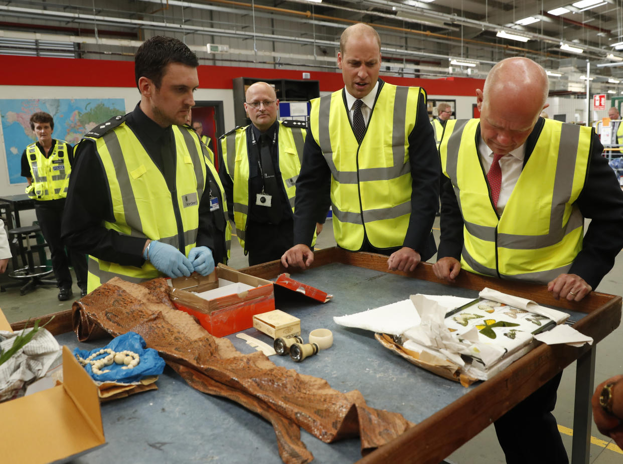 The Duke of Cambridge watches as a UK Border Force shows off their latest seizures, including snake skin and ivory (PA)