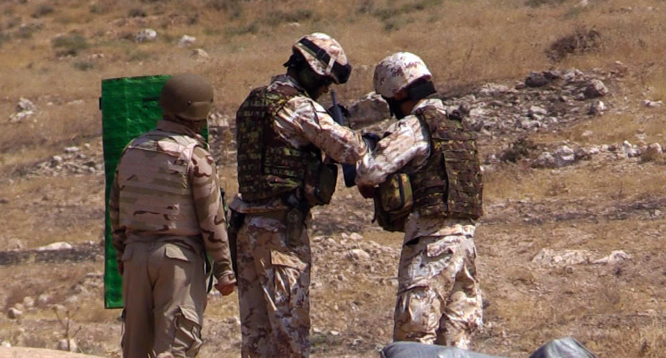 Coalition trainers help Kurdish peshmerga check their shots at the shooting range. (Photo: Ash Gallagher/Yahoo News)