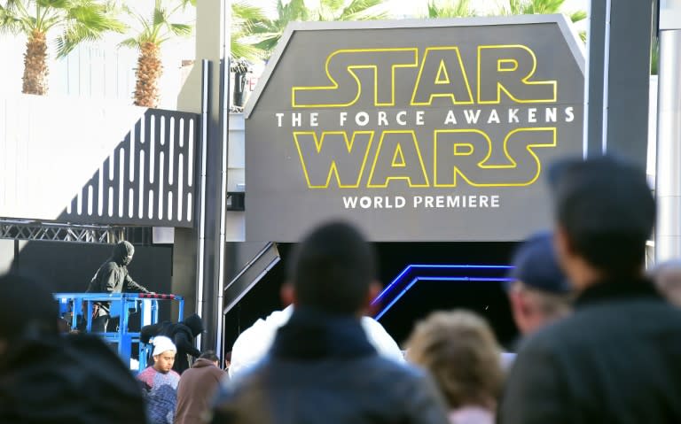 People watch from behind police barricades in Hollywood, California as preparations take place for the premiere of the latest Star Wars film, "The Force Awakens" on December 14, 2015