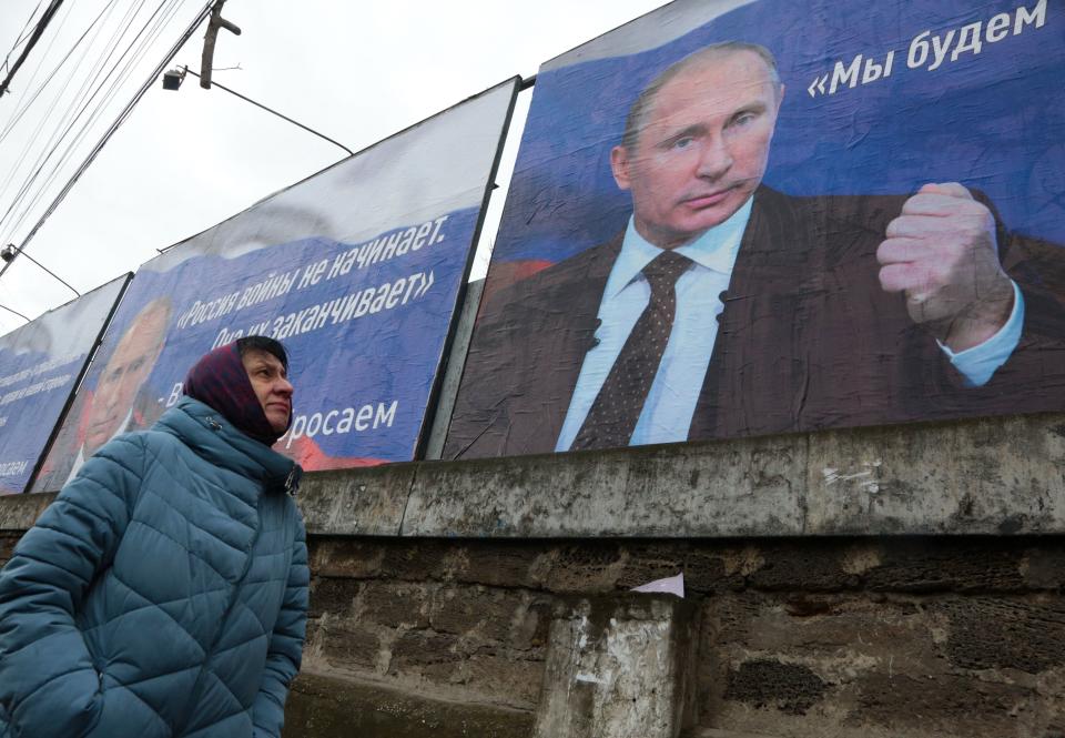 A woman in the city center of Simferopol, Crimea, last March walks past huge placards bearing images of Russian President Vladimir Putin. 